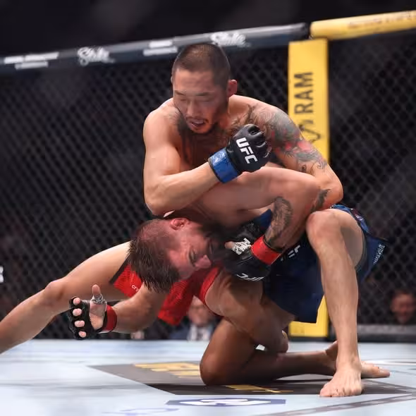 Nyamjargal Tumendemberel controls Cody Durden on the canvas locking in a front headlock position during their bout at UFC 326